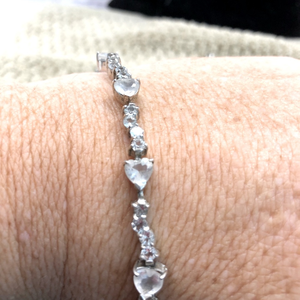 Silver tone bracelet with clear heart shaped crystals.